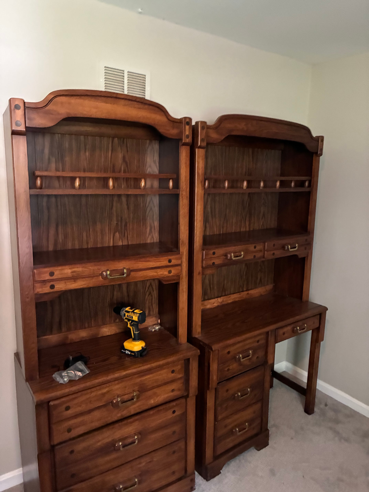 Two large solid wood desks and bookcases still in a bedroom before removal